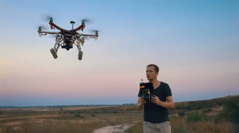 Custom hexacopter flies over a man and flies out of the frame. Slow motion. 動画素材 67499140