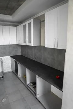 Custom kitchen cabinets installation with a white furniture facades mdf. Gray Stock Photos