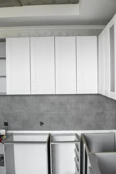 Custom kitchen cabinets installation with a white furniture facades mdf. Gray Stock Photos