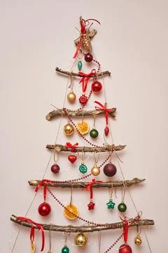 Custom original tree. Christmas tree made of sticks on the wall, decorated with Stock Photos