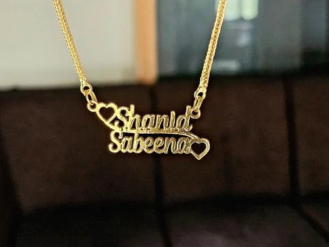 Custom two-name pendant reading "Shanid" and "Sabeena" Stock-Fotos