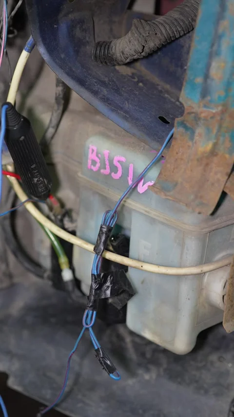 Custom wiring harness connected to a plastic windshield washer tank. Stock Footage 345910251