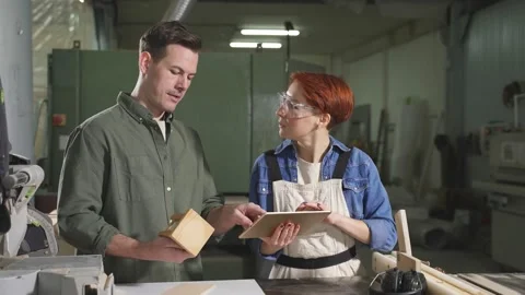 Customer and carpenter have talk in workshop, discussing, sharing ideas what to Stock Footage 164595654