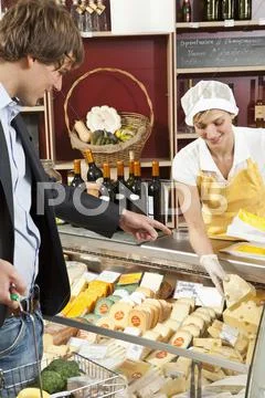 A customer and clerk in a wine and cheese shop Stock Photos