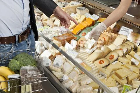 A customer and clerk in a wine and cheese shop Stock Photos