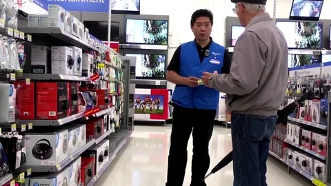 Customer asking clerk about electric appliance questions inside Walmart store Stock Footage 72394885