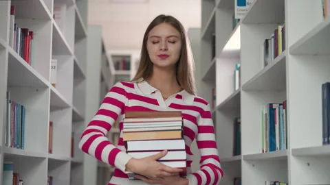 Customer with book stack in store aisle Stock Footage 262755708