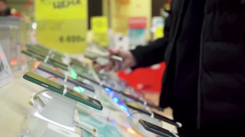 Customer browsing smartphones in a tech store Stock Footage 305975511