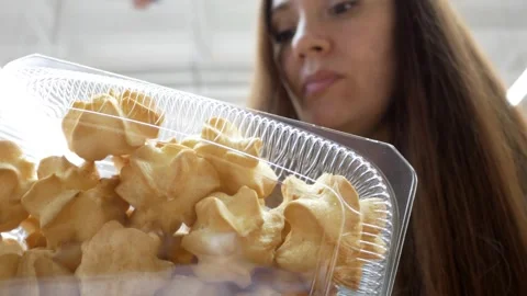 Customer buying eclairs in the pastry section. Woman takes packaged cakes from a Stock Footage 306374916