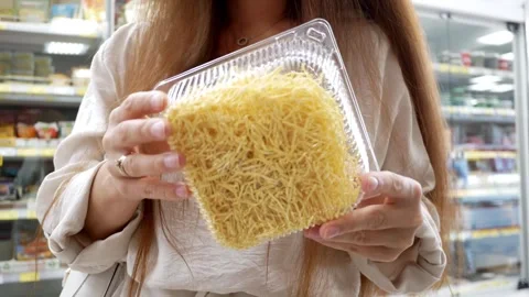 Customer buys packaged instant noodles in grocery store and expiration date of t Stock Footage 283832549