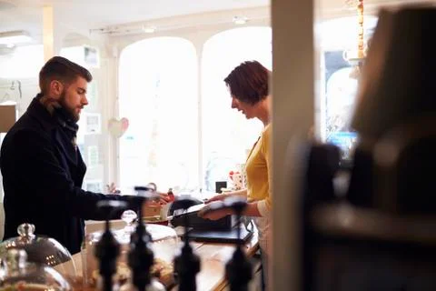 Customer In Cafe Paying Using Reader On Digital Tablet Stock Photos