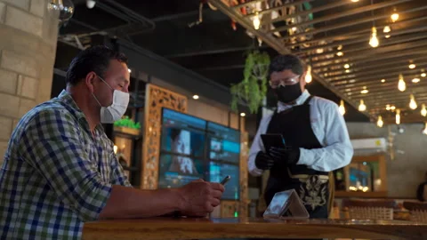 Customer calling waiter in new normal protocol sanitizing covid protocol Video stock 146881975