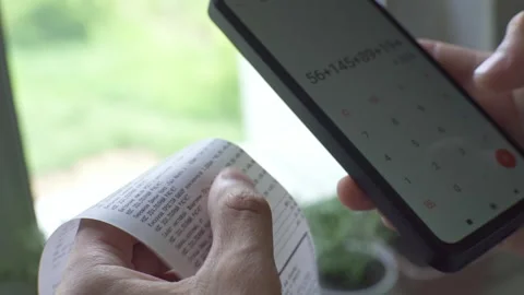 The customer checks the prices in a paper receipt from the grocery store Stock Footage 277876321