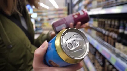 A customer chooses alcoholic drinks in an iron can in a store. Stock Footage 268733408