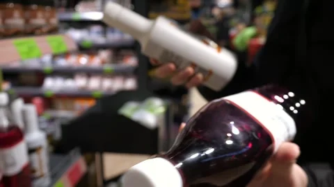 Customer chooses bottled syrup in store Stock Footage 270170044