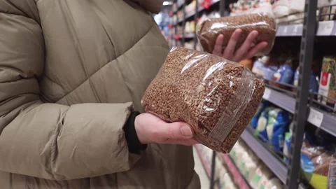 The customer chooses buckwheat in the store. Stock Footage 228881012