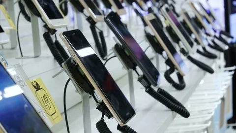 Customer chooses smartphone in electronics store. Video stock 78185095