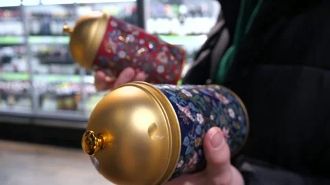 A customer chooses tea in an iron can in a store Stock Footage 270240759