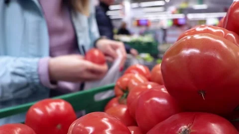 The customer chooses tomatoes in the store. Stock Footage 240132463