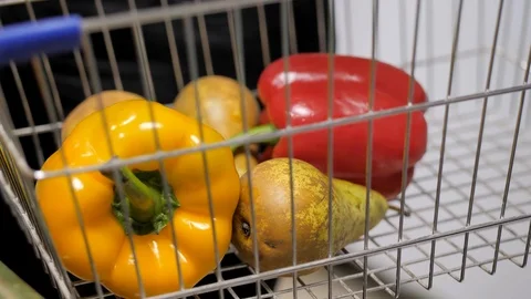 The customer chooses a vegetables and fruit to a basket in the supermarket Stock Footage 125659319