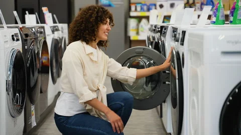 Customer choosing discounted washing machine in electronics store Stock Footage 317733731