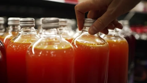 Customer choosing grapefruit juice bottle on supermarket shelf Stock Footage 303591317