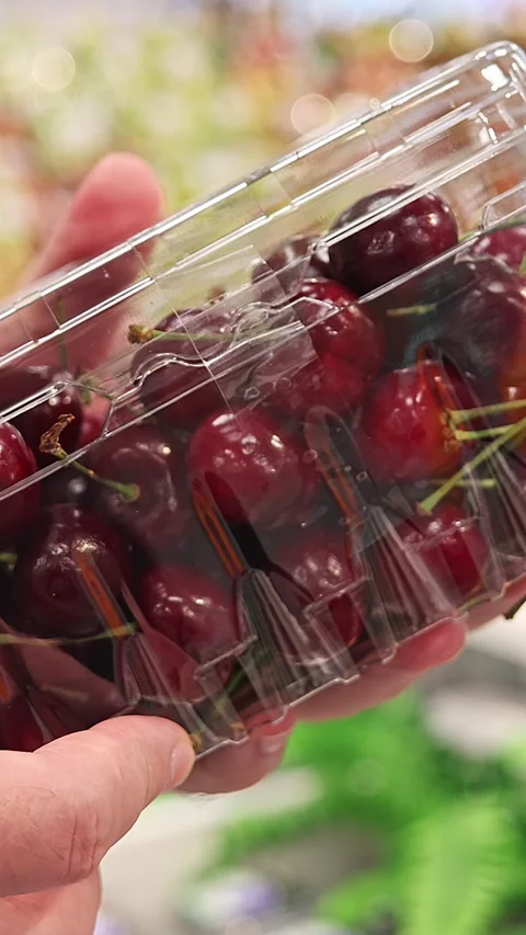Customer choosing packaged cherries in supermarket Stock Footage 336663568