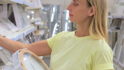 Customer Choosing Wall Clock in Home Goods Store Stock Footage 315018705