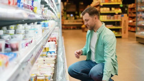 Customer choosing yogurt in dairy section of supermarket Video stock 311935640