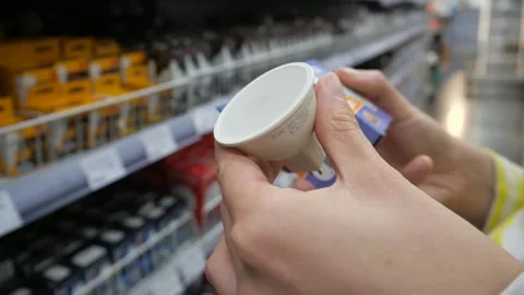 A customer compares light bulbs - a burnt-out one with one sold in a store. Stock Footage 287176049