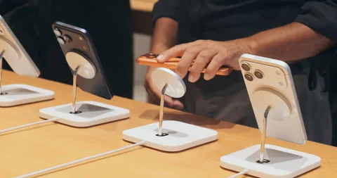 Customer compares new iPhone 17 models at Apple Store. Man choosing smartphone  Stock Footage 322088918