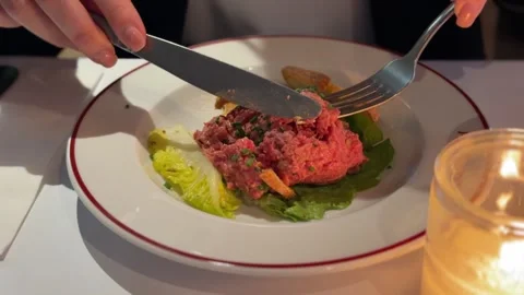 Customer cutting raw beef tartare with knife Stock-Footage 336458568