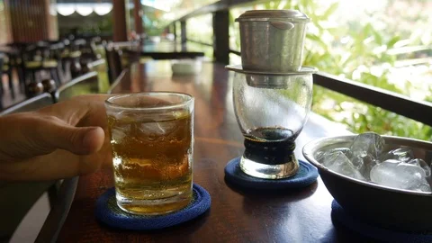 Customer drinks ice tea waits brewing black coffee using a Vietnamese Stock Footage 113678612