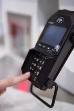Customer entering pin code on a payment terminal, completing a secure trans.. Stockfoto's