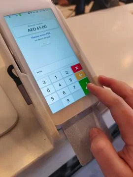 Customer entering PIN code on touch screen pos terminal during credit card .. Foto stock