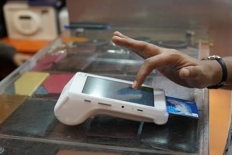 A customer entering security code on credit card reader machine, shopping, cr Stock Photos