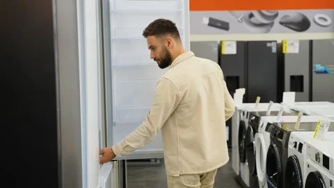 Customer examining refrigerator in electronics store Stock Footage 317725258