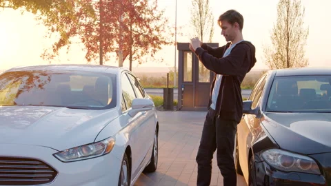 Customer examining two cars before a test drive, capturing details with a Stock Footage 315528232