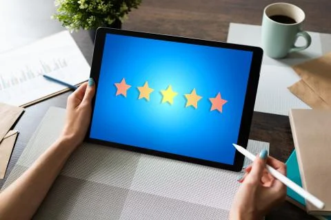 Customer experience satisfaction, feedback, review. Stars icon on device screen. Stock-Fotos