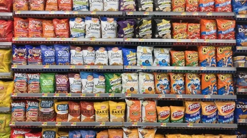 Customer grabbing cheetos from chip shelf at grocery Stock Footage 102672335