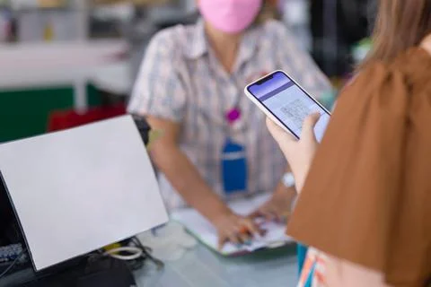 Customer hand scanning qr code for cashless payment at retail shop. Stock Photos