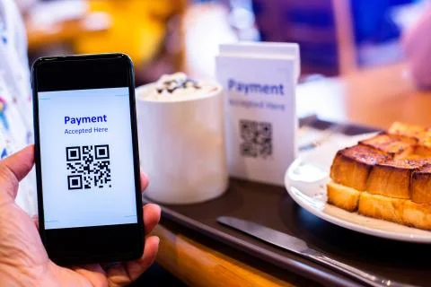 Customer hand using smart phone to scan QR code tag with blur  coffee and bre Фото