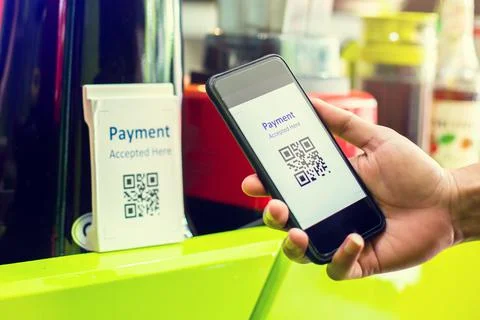 Customer hand using smart phone to scan Qr code payment tag  with blurry coff Stock Photos