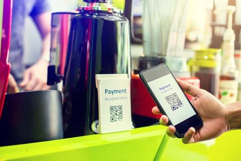 Customer hand using smart phone to scan Qr code payment tag  with blurry coff Stockfoto's