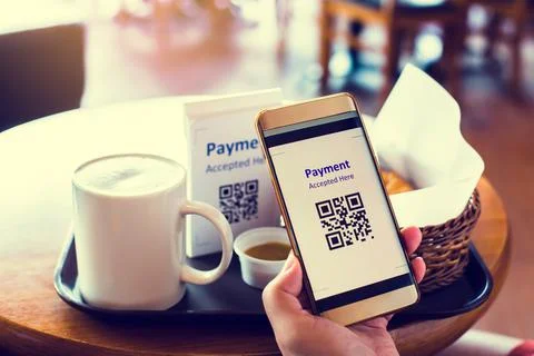Customer hand using smart phone to scan QR code tag with blur coffee and brea Stock Photos