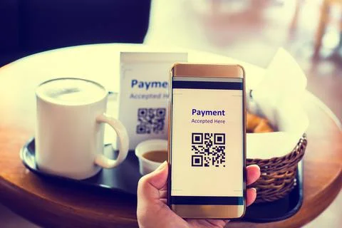 Customer hand using smart phone to scan QR code tag with blur coffee and brea Stockfoto's