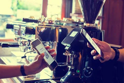 Customer hand using smart phone to scan Qr code payment tag  with blurry coff Foto stock