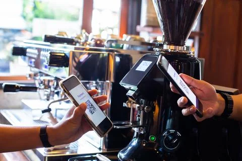 Customer hand using smart phone to scan Qr code payment tag  with blurry coff Stockfoto's