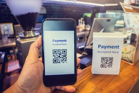 Customer hand using smart phone to scan Qr code payment tag  with blurry coff Stock-Fotos
