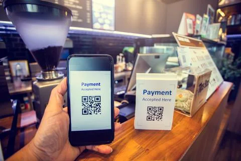 Customer hand using smart phone to scan Qr code payment tag  with blurry coff Stock Photos